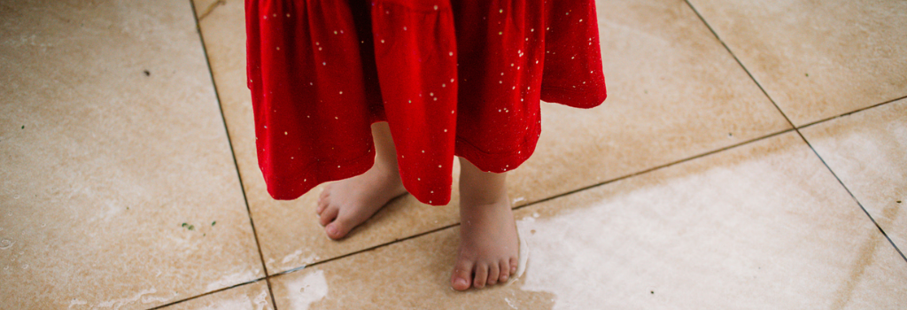 Menina usando vestido vermelho e de pés descalços